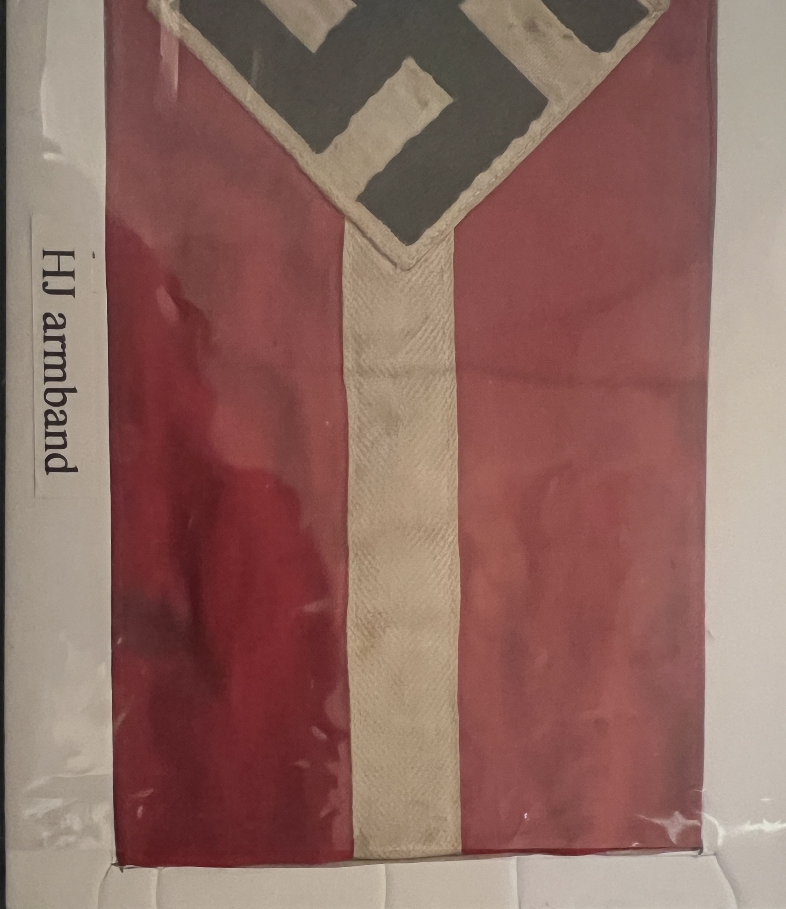 sttriking bold design, black swastika within white diamond, a central white horizontal border either side upon red band